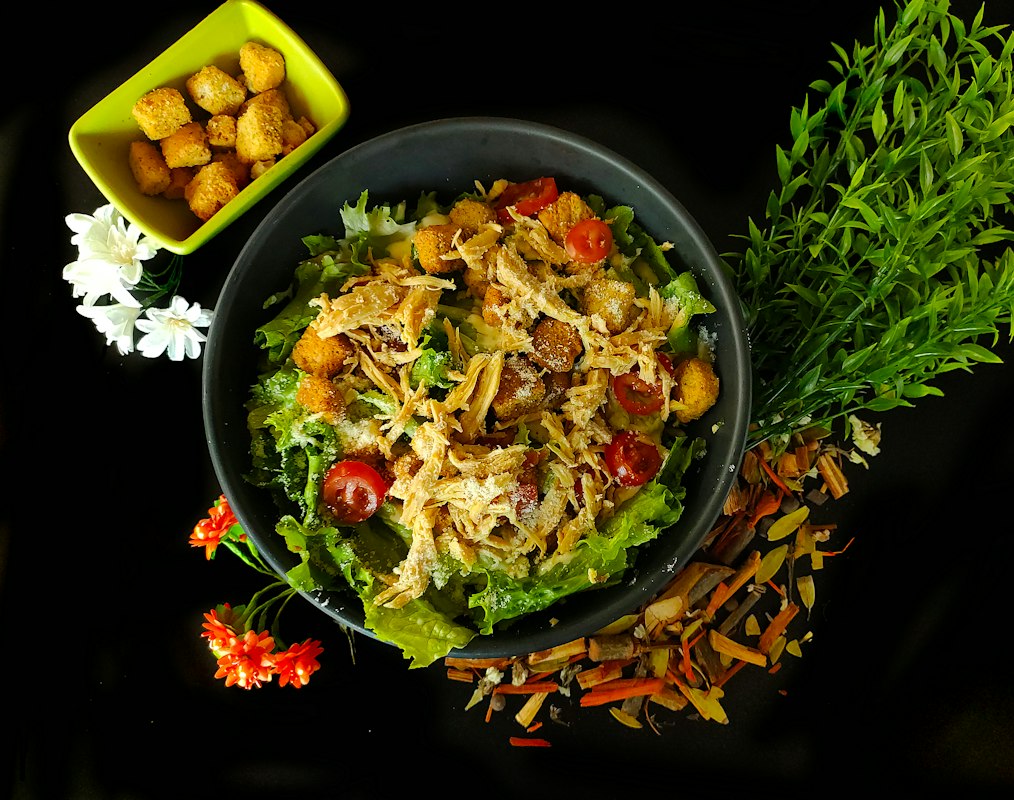 Close-up of fresh salad ingredients including leafy greens, nuts, and colorful vegetables
